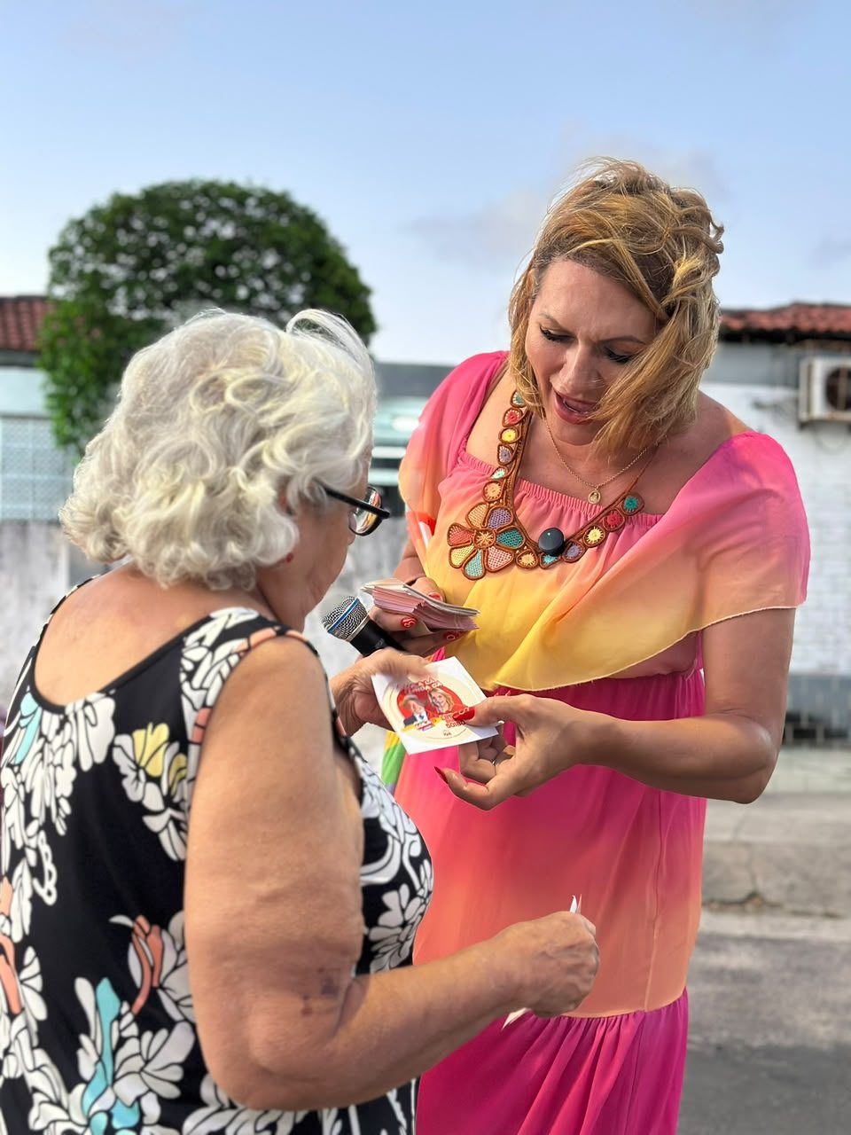 A candidata entrega material de campanha a moradora