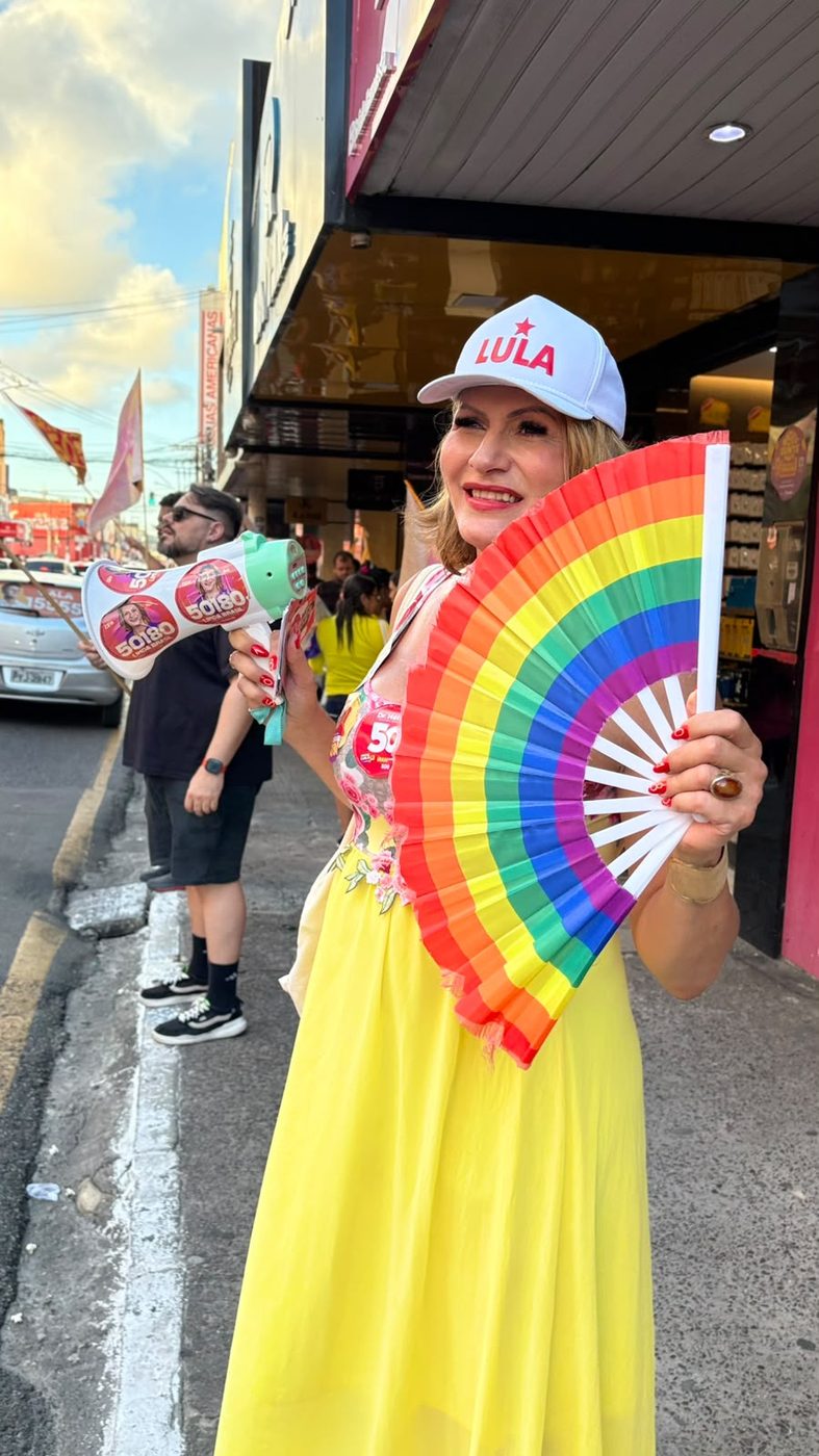 Linda Brasil com leque colorido e boné da campanha de Lula durante atividade no Centro de Aracaju