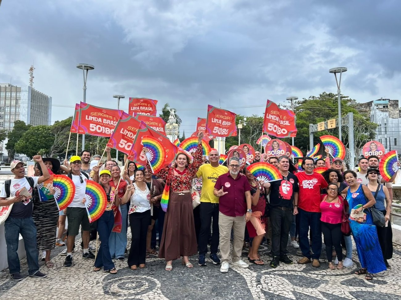 Linda Brasil ao lado de lideranças do Psol e dezenas de apoiadores com bandeiras e leques coloridos no centro de Aracaju